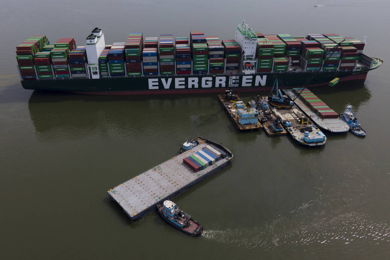 FILE - Tugboats, bottom, align a barge near the container ship Ever Forward, top, which ran aground...