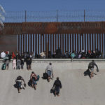 
              Migrants approach the border wall in Ciudad Juarez, Mexico, Wednesday, Dec. 21, 2022, on the other side of the border from El Paso, Texas. Migrants gathered along the Mexican side of the southern border Wednesday as they waited for the U.S. Supreme Court to decide whether and when to lift pandemic-era restrictions that have prevented many from seeking asylum. (AP Photo/Christian Chavez)
            