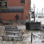 
              Water floods a restaurant terrace during high tide on Long Wharf, Friday, Dec. 23, 2022, in Boston. Winter weather is blanketing the U.S. More than 200 million people — about 60% of the U.S. population — were under some form of winter weather advisory or warning on Friday. (AP Photo/Michael Dwyer)
            