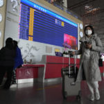 
              Passengers pass near a flight departure board in a Capital airport terminal in Beijing, Tuesday, Dec. 13, 2022. Some Chinese universities say they will allow students to finish the semester from home in hopes of reducing the potential of a bigger COVID-19 outbreak during the January Lunar New Year travel rush. (AP Photo/Ng Han Guan)
            