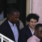 
              FTX founder Sam Bankman-Fried, second right, is escorted out of Magistrate Court toward a Corrections van, following a hearing in Nassau, Bahamas, Monday, Dec. 19, 2022. (AP Photo/Rebecca Blackwell)
            