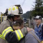 
              Rio Dell assistant fire chief Ryan Heussler, left, hugs Patty, who did not wish to give her last name, as firefighters battled a fire at her home in Rio Dell, Calif., Wednesday, Dec. 21, 2022. (AP Photo/Godofredo A. Vásquez)
            
