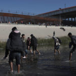 
              Migrants approach the U.S. border wall from Ciudad Juarez, Mexico, Wednesday, Dec. 21, 2022, on the other side of the border from El Paso, Texas. Migrants gathered along the Mexican side of the southern border Wednesday as they waited for the U.S. Supreme Court to decide whether and when to lift pandemic-era restrictions that have prevented many from seeking asylum. (AP Photo/Christian Chavez)
            