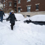 
              Joseph McVay, left, and Sarah Guglielmi who live nearby, walk along a street in the Elmwood Village neighborhood of Buffalo, N.Y. Monday, Dec. 26, 2022, after a massive snow storm blanketed the city. Along with drifts and travel bans, many streets were impassible due to abandoned vehicles. (AP Photo/Craig Ruttle)
            