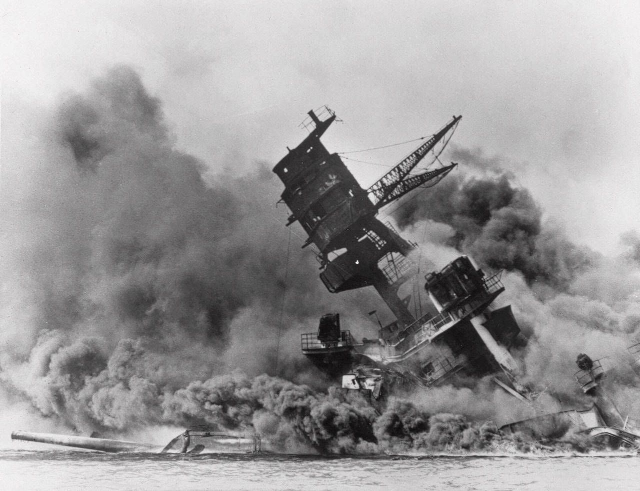 FILE - The battleship USS Arizona belches smoke as it topples over during a Japanese surprise attac...