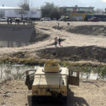 
              Texas National Guard troops patrol the Border in El Paso, Texas, as migrants watch from across the river in Ciudad Juárez, Mexico on Tuesday, Dec. 20, 2022. About 400 troops arrived early Tuesday morning to secure the border with Humvees and concertina wire. (AP Photo/Giovanna Dell’Orto)
            