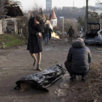 
              A man reacts next to the body of his wife, killed during a Russian attack in Kyiv, Ukraine, Saturday, Dec. 31, 2022. (AP Photo/Roman Hrytsyna)
            