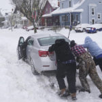 
              Neighbors help push a motorist stuck in the snow in Buffalo, N.Y., on Monday, Dec. 26, 2022. (Derek Gee/The Buffalo News via AP)
            