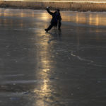 
              A resident takes a selfie as he skates on a frozen canal near sunset in Beijing, Wednesday, Dec. 28, 2022. China says it will resume issuing passports for tourism in another big step away from anti-virus controls that isolated the country for almost three years, setting up a potential flood of Chinese going abroad for next month's Lunar New Year holiday. (AP Photo/Ng Han Guan)
            