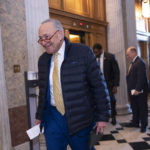 
              Senate Majority Leader Chuck Schumer, D-N.Y., walks to the chamber after speaking with Sen. Chris Coons, D-Del., right, as lawmakers rush to complete passage of a $1.7 trillion bill to fund the government before a midnight Friday deadline or face the prospect of a partial government shutdown going into the Christmas holiday, at the Capitol in Washington, Wednesday, Dec. 21, 2022. (AP Photo/J. Scott Applewhite)
            