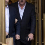 
              FTX founder Sam Bankman-Fried, left, is escorted to his car from the U.S. District Court in Manhattan, Thursday, Dec. 22, 2022, in New York. Bankman-Fried's parents agreed to sign a $250 million bond and keep him at their California home while he awaits trial on charges that he swindled investors and looted customer deposits on his FTX trading platform.  (AP Photo/Julia Nikhinson)
            