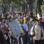 
              Devotees of the Virgin of Guadalupe walk to the Basilica to give thanks or worship a day before her national celebration in Mexico City, on Sunday, Dec. 11, 2022. (AP Photo/Ginnette Riquelme)
            