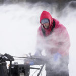 
              Mark Sorter clears snow from a downtown ice skating rink, Friday, Dec. 23, 2022, in Des Moines, Iowa. (AP Photo/Charlie Neibergall)
            