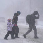 
              The Firestone family makes their way across Elmwood Avenue in Buffalo, N.Y. after stocking up on supplies at the grocery store, Friday, Dec. 23, 2022. Winter weather is blanketing the U.S. as a massive storm sent temperatures crashing and created whiteout conditions.(Derek Gee /The Buffalo News via AP)
            