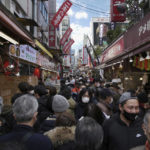 
              People walk through a shopping street in the Ueno district famous for a year-end shopping before New Year holidays in Tokyo, Friday, Dec. 30, 2022. (AP Photo/Hiro Komae)
            