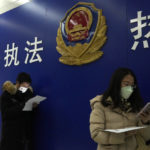 
              Residents line up at the community police station for document applications including for passports near the words "Strict law enforcement, enthusiastic service" in Beijing, Wednesday, Dec. 28, 2022. China says it will resume issuing passports for tourism in another big step away from anti-virus controls that isolated the country for almost three years, setting up a potential flood of Chinese going abroad for next month's Lunar New Year holiday. (AP Photo/Ng Han Guan)
            