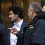
              FTX founder Sam Bankman-Fried, center, is escorted to his car from the U.S. District Court in Manhattan, Thursday, Dec. 22, 2022, in New York. Bankman-Fried's parents agreed to sign a $250 million bond and keep him at their California home while he awaits trial on charges that he swindled investors and looted customer deposits on his FTX trading platform. (AP Photo/Julia Nikhinson)
            