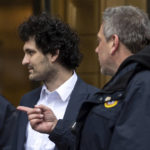 
              FTX founder Sam Bankman-Fried, center, is escorted to his car from the U.S. District Court in Manhattan, Thursday, Dec. 22, 2022, in New York. Bankman-Fried's parents agreed to sign a $250 million bond and keep him at their California home while he awaits trial on charges that he swindled investors and looted customer deposits on his FTX trading platform. (AP Photo/Julia Nikhinson)
            