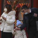 
              A couple buy a sugar-coated Chinese haw to a child at the Qianmen pedestrian shopping street, a popular tourist spot in Beijing, Tuesday, Jan. 3, 2023. As the virus continues to rip through China, global organizations and governments have called on the country start sharing data while others have criticized its current numbers as meaningless. (AP Photo/Andy Wong)
            