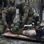 Military medics give first aid to a soldier wounded in a battle near Kremenna in the Luhansk region, Ukraine, Monday, Jan. 16, 2023. (AP Photo/LIBKOS)