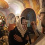 
              An Orthodox priest offers the holy communion to a woman during Christmas church service in Kostyantynivka, Ukraine, Friday, Jan. 6, 2023. (AP Photo/Evgeniy Maloletka)
            