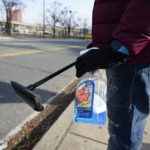 
              Shamonte Jones holds a bottle of window washing fluid and a squeegee as he waits for commuters to let him clean their vehicle's windshield in exchange for cash, Tuesday, Jan. 10, 2023, in Baltimore. Local officials are rolling out their latest plan to steer squeegee workers away from busy downtown intersections and toward formal employment using law enforcement action and outreach efforts. (AP Photo/Julio Cortez)
            