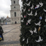 
              Ukrainian couple kiss each other in front of a Chrismas tree outside the St. Sophia cathedral in Kyiv, Ukraine, Friday, Jan. 6, 2023. Russian President Vladimir Putin on Thursday ordered Moscow's armed forces to observe a 36-hour cease-fire in Ukraine this weekend for the Russian Orthodox Christmas holiday, but Ukrainian President Volodymyr Zelenskyy questioned the Kremlin's intentions, accusing the Kremlin of planning the fighting pause "to continue the war with renewed vigor". (AP Photo/Bela Szandelszky)
            