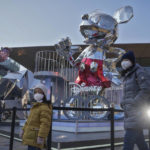 
              A woman and a child wearing face masks walk by a Mickey Mouse statue on display at an outdoor shopping center commemorating Disney 100th anniversary, in Beijing, Thursday, Jan. 5, 2023. As COVID-19 rips through China, other countries and the WHO are calling on its government to share more comprehensive data on the outbreak, with some even saying many of the numbers it is reporting are meaningless. (AP Photo/Andy Wong)
            