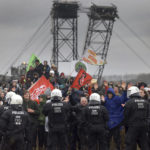 
              Police officers block demonstrators on the edge of the opencast lignite mine Garzweiler at the village Luetzerath near Erkelenz, Germany, Saturday, Jan. 14, 2023. ( Oliver Berg/dpa via AP)
            