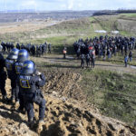 
              Police officers have surrounded a group of activists and coal opponents on the edge of the Garzweiler II lignite open pit mine during a protest by climate activists following the clearance of Luetzerath, Germany, Tuesday, Jan. 17, 2023.  After the eviction of Luetzerath ended on Sunday, coal opponents continued their protests on Tuesday at several locations in North Rhine-Westphalia. (Federico Gambarini/dpa via AP)
            