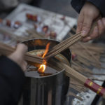 
              Visitors light incense as they pray on the first day of the Lunar New Year holiday at the Lama Temple in Beijing, Sunday, Jan. 22, 2023. People across China rang in the Lunar New Year on Sunday with large family gatherings and crowds visiting temples after the government lifted its strict "zero-COVID" policy, marking the biggest festive celebration since the pandemic began three years ago. (AP Photo/Mark Schiefelbein)
            