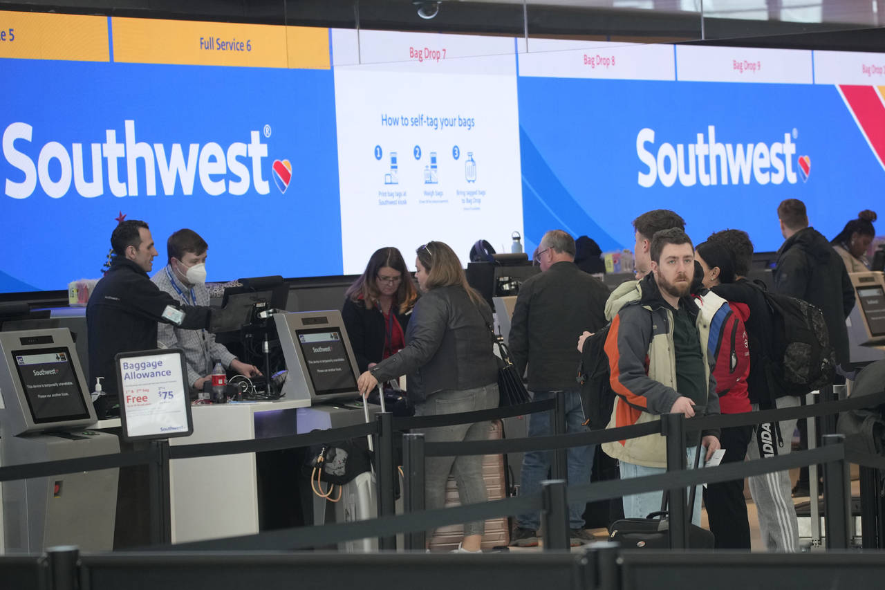 FILE - Travelers queue up at the check-in counters for Southwest Airlines in Denver International A...