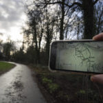 
              A cameraman holds a mobile phone showing the map of the buried Nazi loot on the location of the former dirt road in Ommeren, near Arnhem, Netherlands, Thursday, Jan. 19, 2023. A hand-drawn map with a red letter X purportedly showing the location of a buried stash of precious jewelry looted by Nazis from a blown-up bank vault has sparked a modern-day treasure hunt in a tiny Dutch village. (AP Photo/Peter Dejong)
            