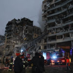 
              Emergency workers clear the rubble after a Russian rocket hit a multistory building leaving many people under debris in Dnipro, Ukraine, Saturday, Jan. 14, 2023. (AP Photo/Roman Chop)
            