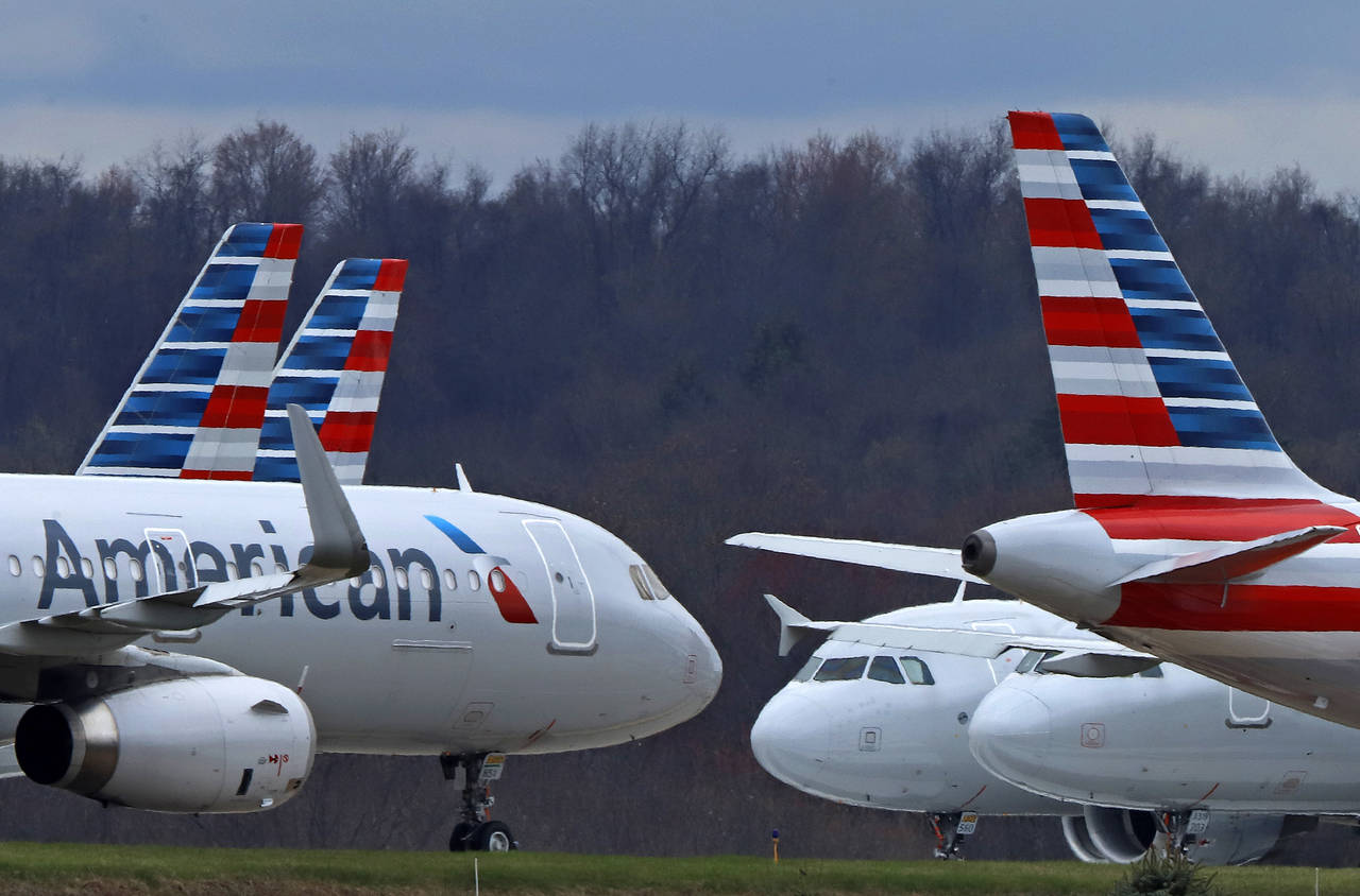 FILE - American Airlines planes sit stored at Pittsburgh International Airport on March 31, 2020, i...
