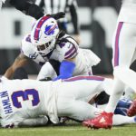 
              Buffalo Bills safety Damar Hamlin (3) lies on the turf after making a tackle on Cincinnati Bengals wide receiver Tee Higgins, blocked from view, as Buffalo Bills linebacker Tremaine Edmunds (49) assists at the end of the play during the first half of an NFL football game between the Cincinnati Bengals and the Buffalo Bills, Monday, Jan. 2, 2023, in Cincinnati. After getting up from the play, Hamlin collapsed and was administered CPR on the field. (AP Photo/Joshua A. Bickel)
            