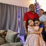
              The Purdy family pose for a photo at home in Kapolei, Hawaii, on Wednesday, Dec. 14, 2022. The family moved to Las Vegas in 2017 to escape Hawaii's high cost of living and returned last year and share two bedrooms in a home they rent with extended family. Native Hawaiians, like the Purdys, who have been priced out of Hawaii are finding more affordable places to live in cities like Las Vegas. (AP Photo/Jennifer Sinco Kelleher)
            
