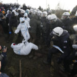 
              Police officers scuffle with demonstrators at the village of Luetzerath near Erkelenz, Germany, Tuesday, Jan. 10, 2023. The village of Luetzerath is occupied by climate activists fighting against the demolishing of the village to expand the Garzweiler lignite coal mine near the Dutch border. Poster read: „1,5 degrees celsius means: Luetzerath stays". (AP Photo/Michael Probst)
            