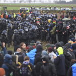 
              Police officers form a line to block demonstrators on the edge of the opencast lignite mine Garzweiler at the village Luetzerath near Erkelenz, Germany, Saturday, Jan. 14, 2023. ( Oliver Berg/dpa via AP)
            