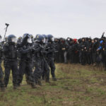 
              Police officers form a line to block demonstrators on the edge of the opencast lignite mine Garzweiler at the village Luetzerath near Erkelenz, Germany, Saturday, Jan. 14, 2023. ( Oliver Berg/dpa via AP)
            