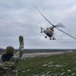 
              A Ukrainian soldier waves to a military helicopter returning from the combat, close to the frontline in the Kherson region, Ukraine, Sunday, Jan. 8, 2023. (AP Photo/LIBKOS)
            