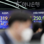 A currency trader watches computer monitors near the screens showing the Korea Composite Stock Price Index (KOSPI), left, and the foreign exchange rate between U.S. dollar and South Korean won at a foreign exchange dealing room in Seoul, South Korea, Monday, Jan. 9, 2023. Shares have climbed in Asia following a rally on Wall Street, where investors bet that slow U.S. wage gains may augur a cooling of the inflation that has led the Federal Reserve to hike interest rates. (AP Photo/Lee Jin-man)