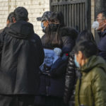 
              A family member carrying the photo of a deceased relative outside a mortuary of a hospital in Beijing, Thursday, Jan. 5, 2023. As COVID-19 rips through China, other countries and the WHO are calling on its government to share more comprehensive data on the outbreak, with some even saying many of the numbers it is reporting are meaningless. (AP Photo/Andy Wong)
            