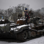 
              A boy stands on a destroyed Russian tank displayed in downtown Kyiv, Ukraine, Tuesday Jan. 31, 2023. (AP Photo/Daniel Cole)
            