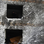 
              A local resident is seen in a window hole of an apartment building damaged in the night following a Russian rocket attack in Zaporizhzhya, Ukraine, Monday, Jan. 16, 2023. (AP Photo/Andriy Andriyenko)
            