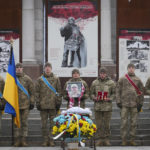 
              Ukrainian servicemen stand guard the coffin of their comrade Oleh Yurchenko killed in a battlefield with Russian forces in Donetsk region during a commemoration ceremony in Independence Square in Kyiv, Ukraine, Sunday, Jan. 8, 2023. (AP Photo/Efrem Lukatsky)
            