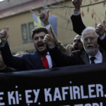 
              Protesters chant slogans as they carry a banner with a crossed-out picture of Swedish politician Rasmus Paludan and a Quranic verse reading "Say this: Oh non-believers, you will be defeated and you shall be gathered and exiled unto hell" during a demonstration outside the Swedish embassy in Ankara, Turkey, Saturday, Jan. 21, 2023. Far-right activist Paludan has received permission from police to stage a protest outside the Turkish Embassy in Stockholm, where he intends to burn the Quran, Islam's holy book. (AP Photo/Burhan Ozbilici)
            
