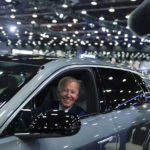
              FILE - President Joe Biden drives a Cadillac Lyriq through the showroom during a tour at the Detroit Auto Show, Sept. 14, 2022, in Detroit. Biden persuaded Democrats in Congress to provide hundreds of billions of dollars to fight climate change. Now comes another formidable task: enticing Americans to buy millions of electric cars, heat pumps, solar panels and more efficient appliances.  (AP Photo/Evan Vucci, File)
            