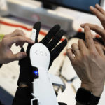 An attendee looks at Haptic Metaverse Gloves by AI Silk during the CES tech show Thursday, Jan. 5, 2023, in Las Vegas. (AP Photo/John Locher)