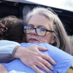 
              Jessie Blanchard, center, kisses and hugs a participant arriving to receive help with food, Naloxone, needles, tourniquets, condoms and other goods on Monday, Jan. 23, 2023, in Albany, Ga. (AP Photo/Brynn Anderson)
            
